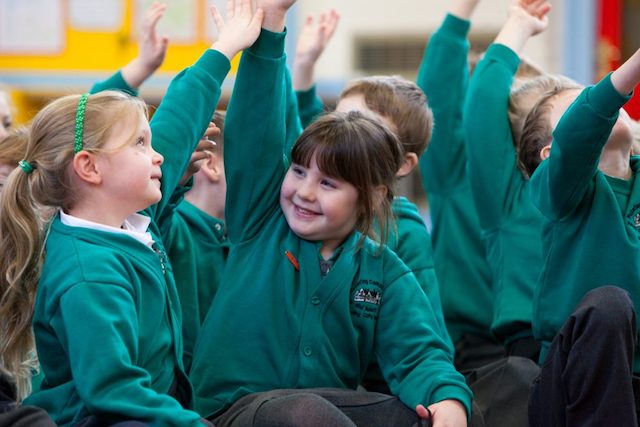 PPA Cover in Primary Schools: children raising their hands